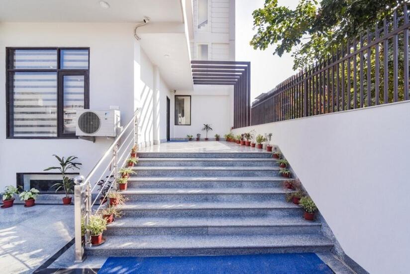 a staircase in a white building with potted plants at Royal Residency 610 Golf View in Gurgaon