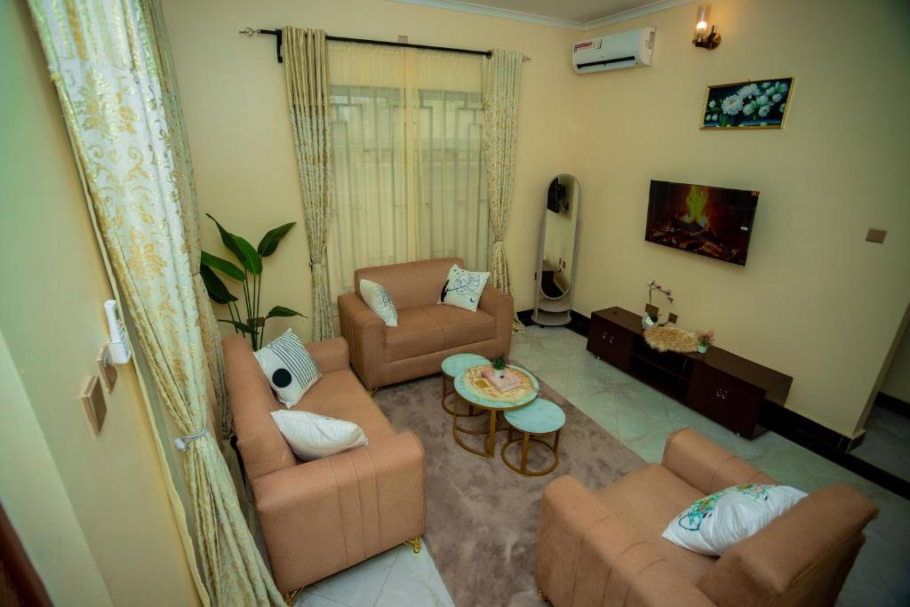 a living room with two couches and a tv at Pristine Stays in Moshi
