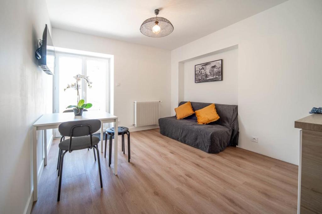 a living room with a couch and a table in a room at Les clés Bélinéenes in Bligny-lès-Beaune