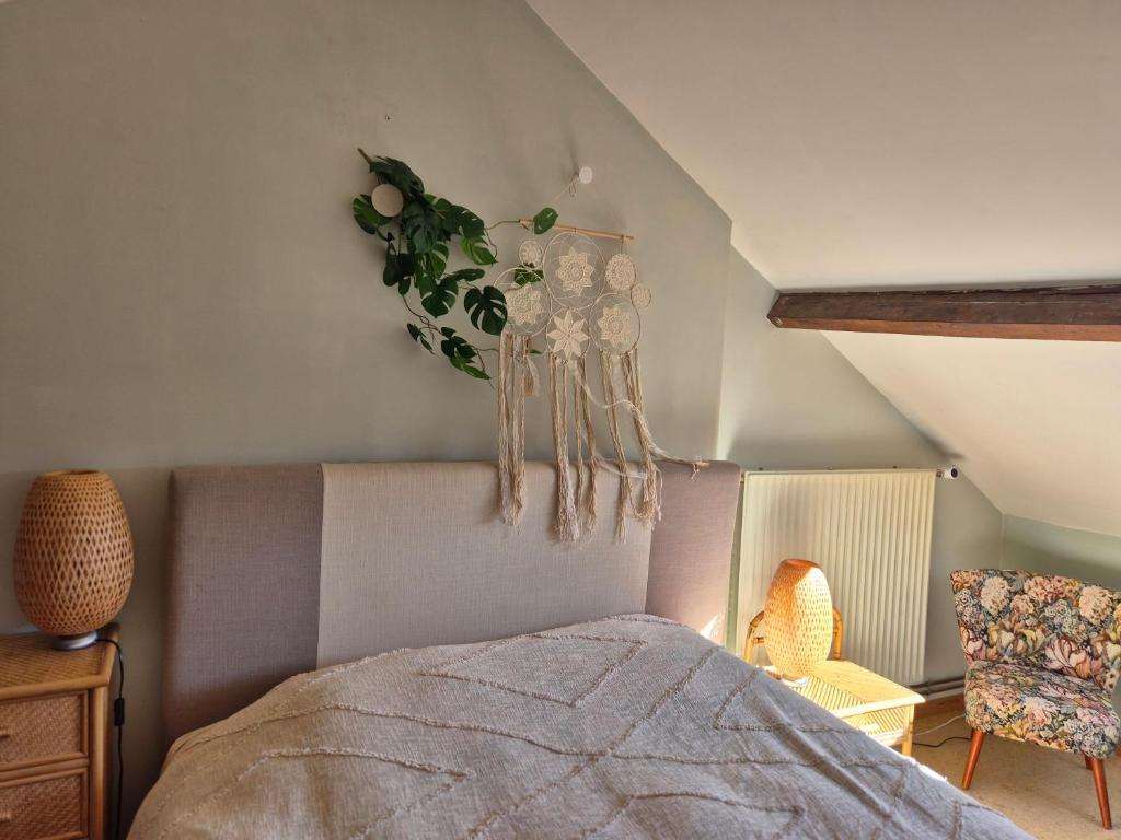 a bedroom with a bed and a plant on the wall at Chambre de Camille à Gerpinnes in Gerpinnes
