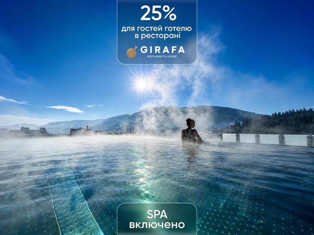 a person standing in a hot tub in a hot mineral water spa at BUKA Apart-Hotel & SPA in Bukovel