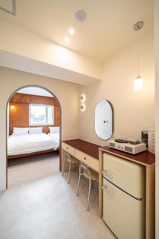 a bedroom with a bed and a desk with a mirror at Monday Mansion Hotel in Seoul