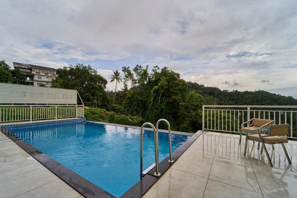 a swimming pool on the balcony of a house at Treebo Belita Resort Munnar With Infinity Pool in Munnar