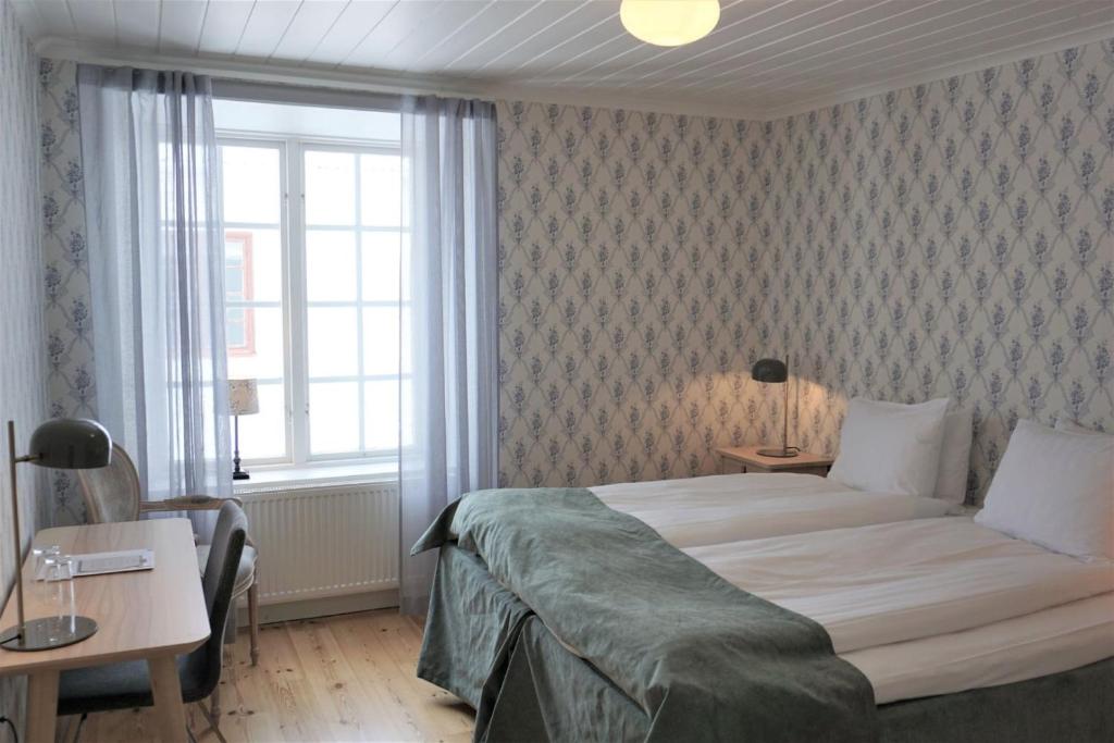 a bedroom with a large bed and a window at Gysinge Herrgård in Österfärnebo