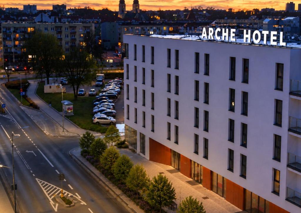 a white building with a hotel sign on top of it at Arche Hotel Piła in Piła