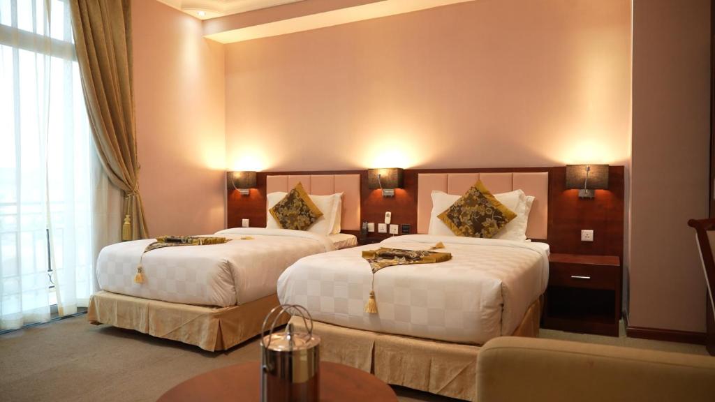 a hotel room with two beds and a couch at Amdina Hotel in Mekʼelē