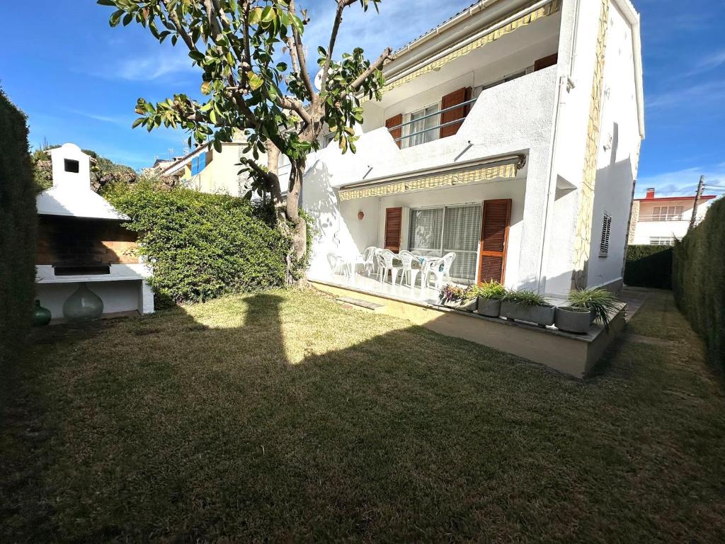 a white house with a lawn in front of it at Adosado Mar i Pins in Benicarló
