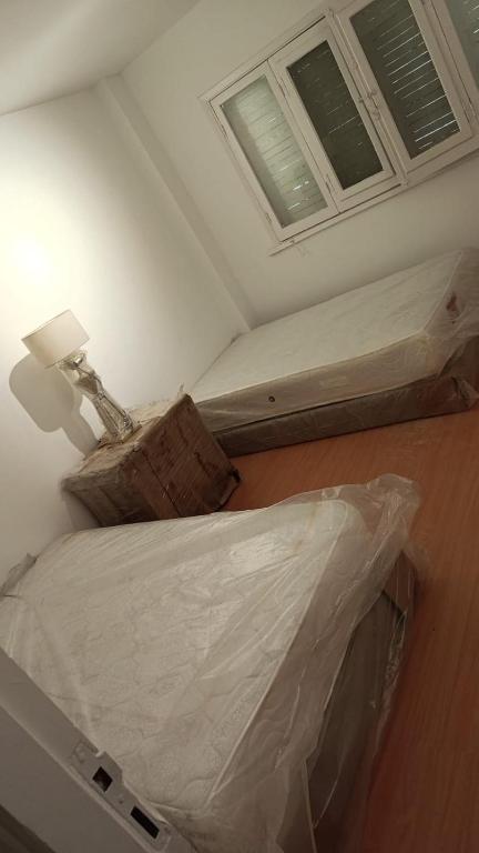 a room with two beds and a lamp in it at Apres-midi in Dawwār Abū Maḩrūs