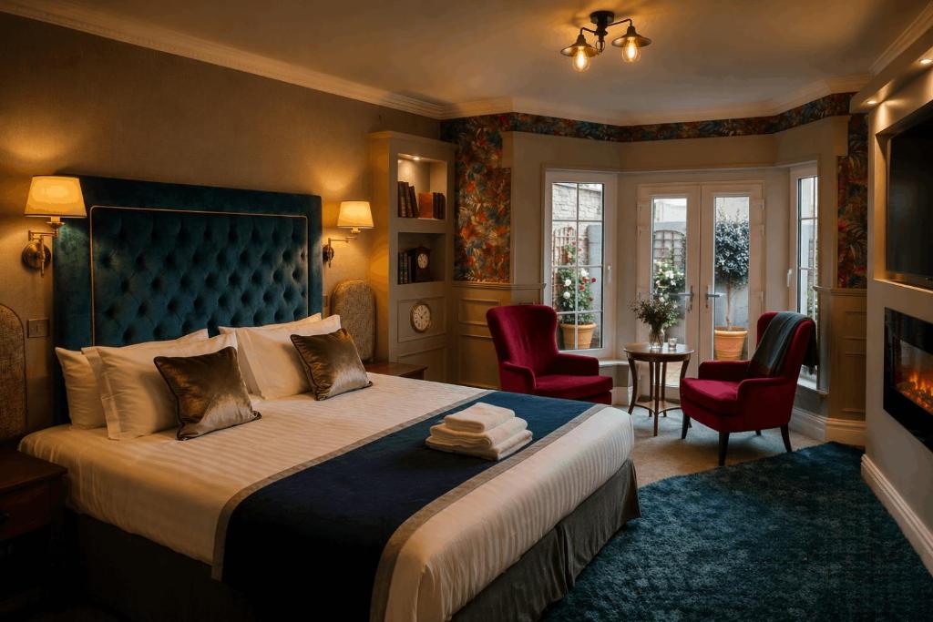 a bedroom with a bed and two chairs and a fireplace at The Véro Townhouse Killarney in Killarney
