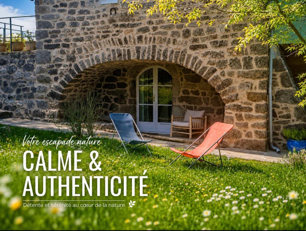 a group of chairs sitting in the grass in front of a building at "La Voûte de Pierre" Gîte indépendant in Saint-Cyr
