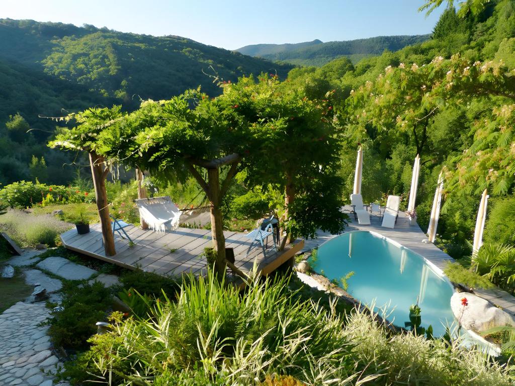 a swimming pool with a view of a mountain at Le Nid Du Dragon Rouge in Courniou