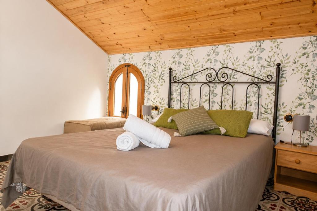 a bedroom with a large bed with towels on it at Refugio La Presa in Chulilla