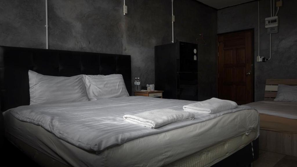 a bedroom with a bed with two towels on it at the loft residence in Ban Plai Khlong Bang Noi