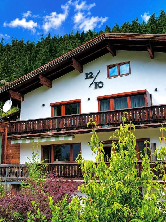 a large white house with a balcony at 1210 Apartments Benglerwald in Bach