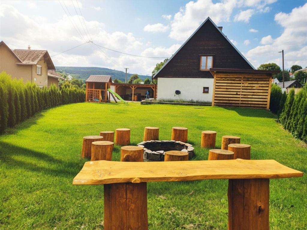 a wooden bench in a yard with a fire pit at Chalupa u dvou žab in Janov