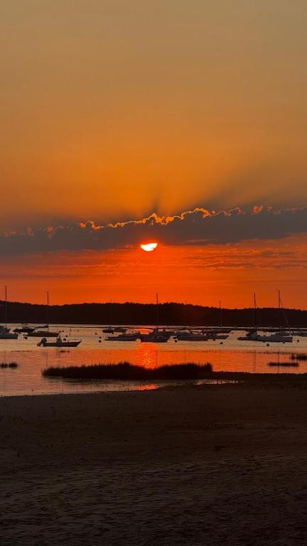 a sunset over a body of water with boats at Maisonnette in Arès