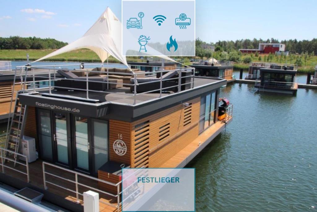 a boat is docked at a dock in the water at Floatinghouse Seensucht in Klitten