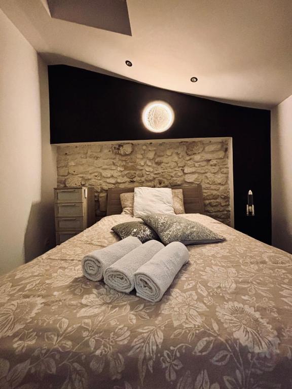 a bedroom with a large bed with towels on it at La Suite du Maine SAINTES in Saintes