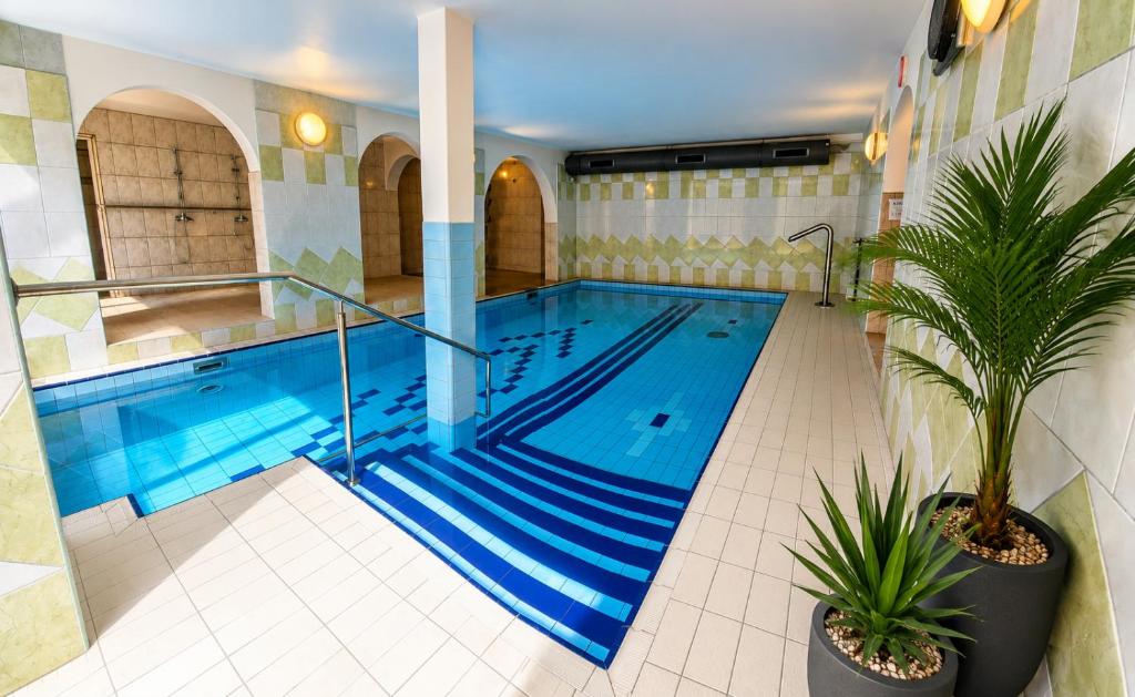 a large swimming pool with blue water in a building at Dom Wczasowy GLOBUS in Ustroń