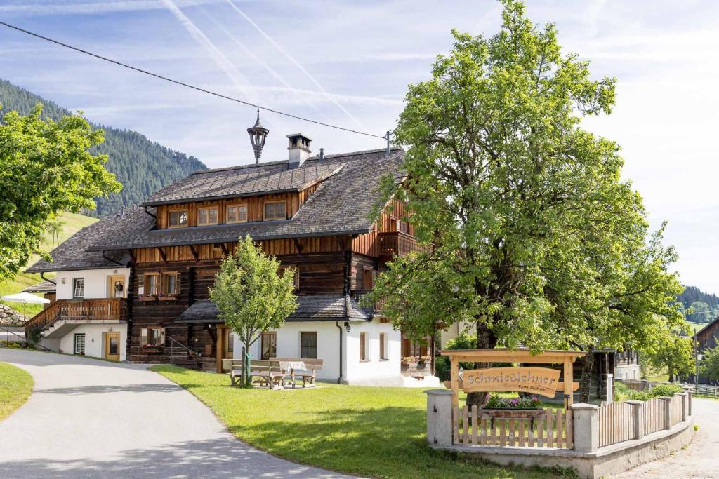 a large wooden house in the middle of a park at Schmiedlehnerhof in Birnberg