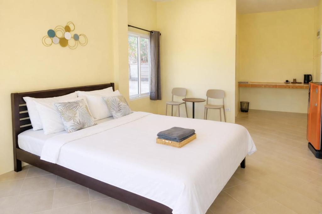 a bedroom with a large white bed and a table at Koniix Garden Cottage Ko Sichang in Ko Si Chang