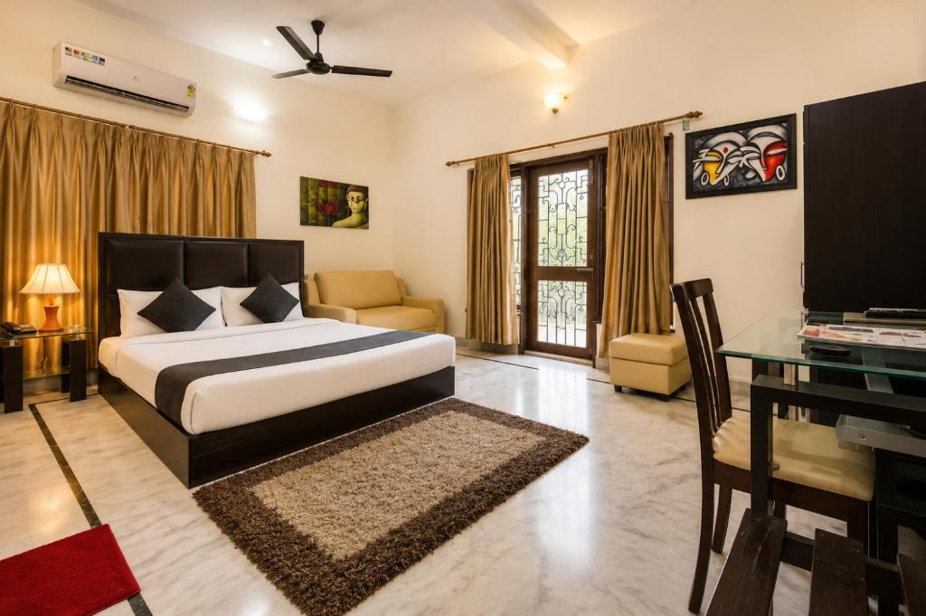 a bedroom with a bed and a desk and a television at Next Generation Guest House in kolkata