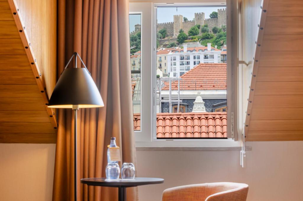 a view from a room with a table and a window at Ouro Rossio Hotel in Lisbon