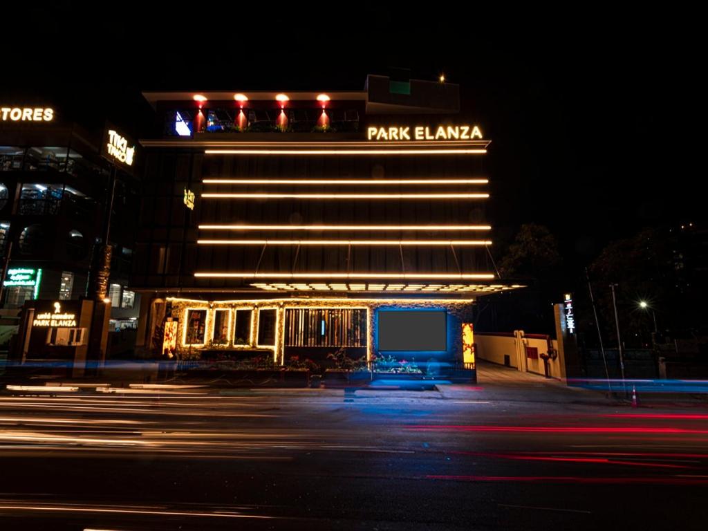 a park hawaiian hotel at night with a building at Hotel Park Elanza Coimbatore in Coimbatore