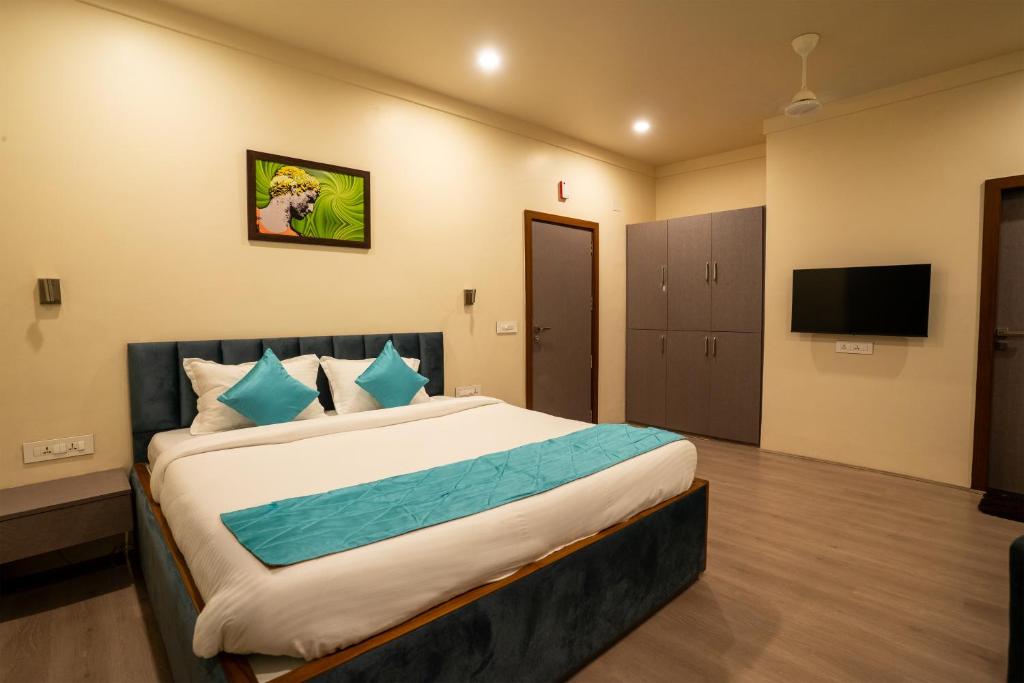 a bedroom with a large bed and a flat screen tv at Fit Haus - A Boutique Hotel in Kolkata