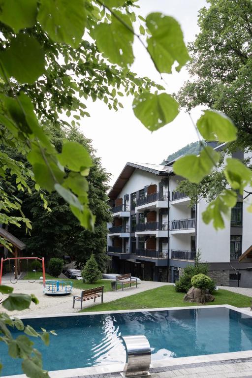 an apartment building with a pool and a playground at Apartel Shayan in Shaian