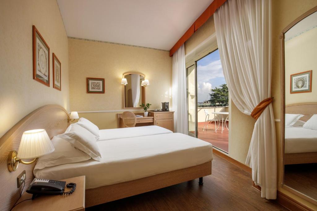 Hotel Santa Costanza by OMNIA hotels tesisinde bir odada yatak veya yataklar