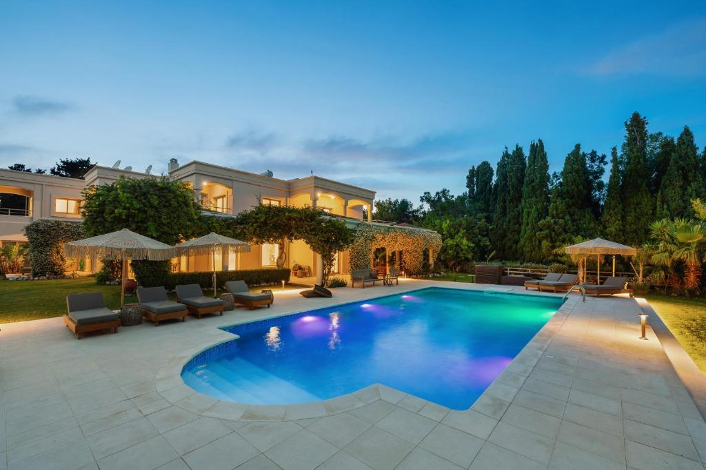 a swimming pool in the backyard of a house at Bello Blu Estate Luxury Mediterranean Villa in Asgourou