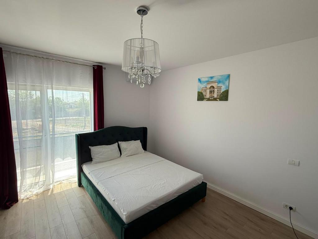 a bedroom with a bed and a chandelier at VISAJ Escape in Timişoara