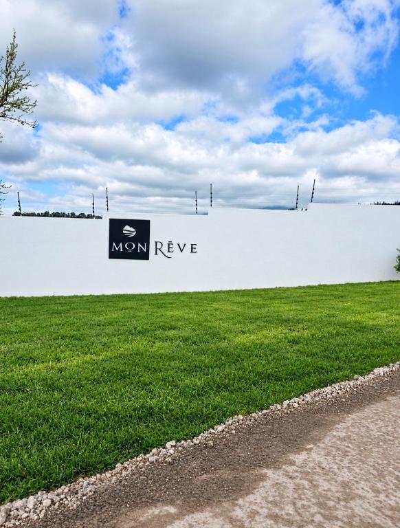 a white wall with a sign on the side of a field at Mon Rêve Estate in Cape Town