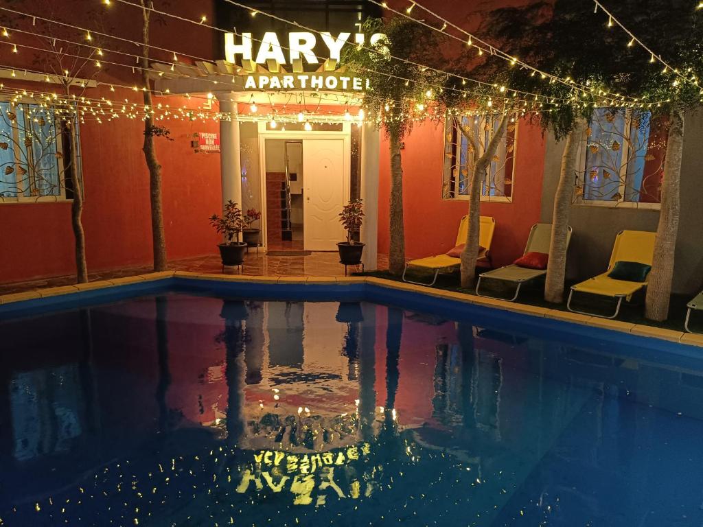 a hotel swimming pool with lights and a sign that reads harpy apartment hotel at Hary's Aparthotel in Toliara