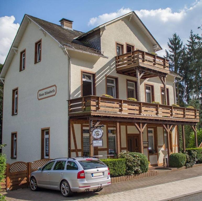 a car parked in front of a house with a balcony at Gästehaus Elisabeth in Schlangenbad