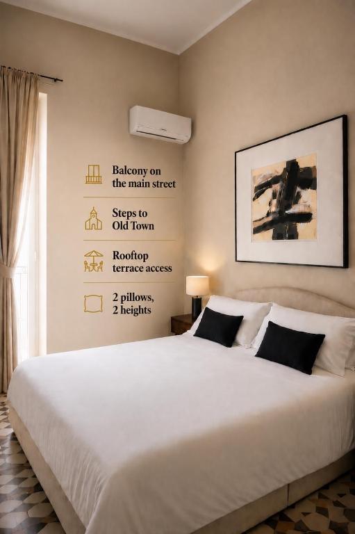 a bedroom with a white bed with a poster on the wall at Bari LandLord 71 - Private Balcony Suites in Bari