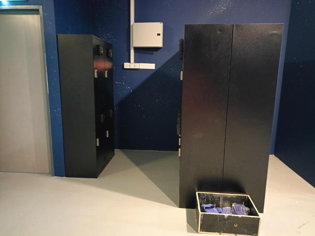 a locker room with a box of purple shoes at Galaxy Capsule Hotel near Hitech in Kulim