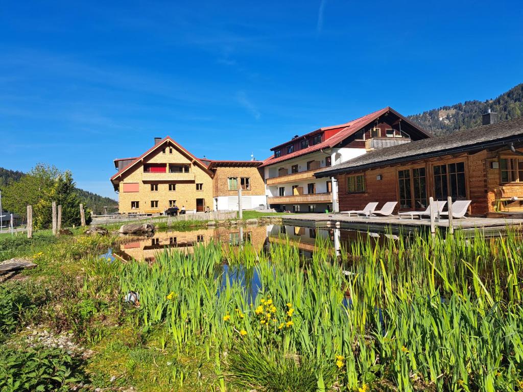 a group of buildings next to a body of water at Almhof Lässer in Balderschwang