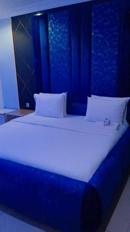 a large bed in a room with blue walls at Savannah Suites in Gwarinpa