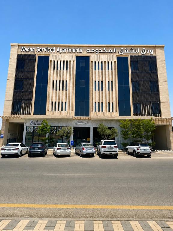 a building with cars parked in a parking lot at ودق للشقق المخدومة in Riyadh