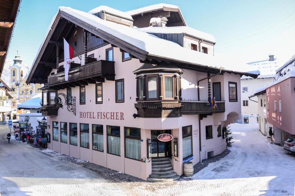 a hotelier building with snow on top of it at Hotel Fischer in Sankt Johann in Tirol