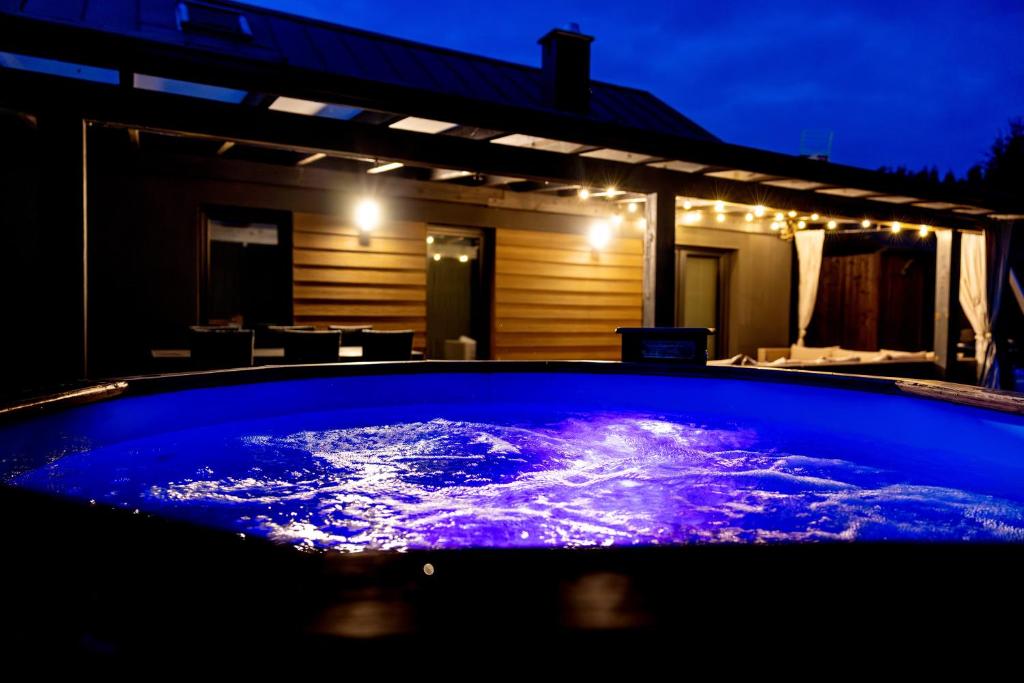 a hot tub with purple lights in front of a house at LR10 Dom Wakacyjny in Lubogoszcz