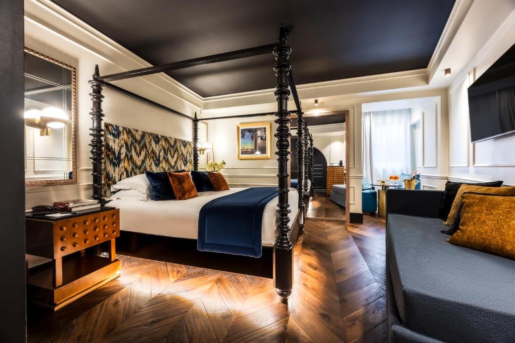 a bedroom with a four poster bed and a couch at Argentum Boutique Hotel & SPA in Rome
