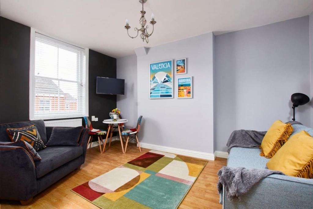 a living room with a couch and a table at Delven House - Self Check-in, Self-Catering Serviced Apartments in Castle Donington