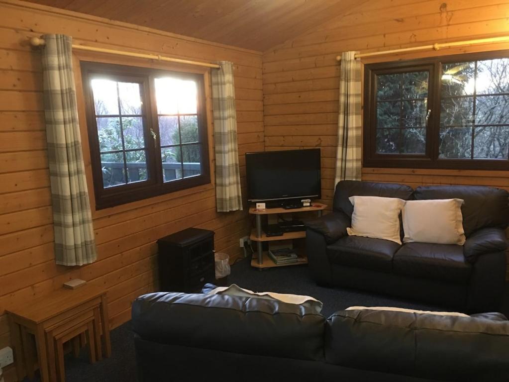 a living room with a couch and a flat screen tv at Rowantree View in Roybridge