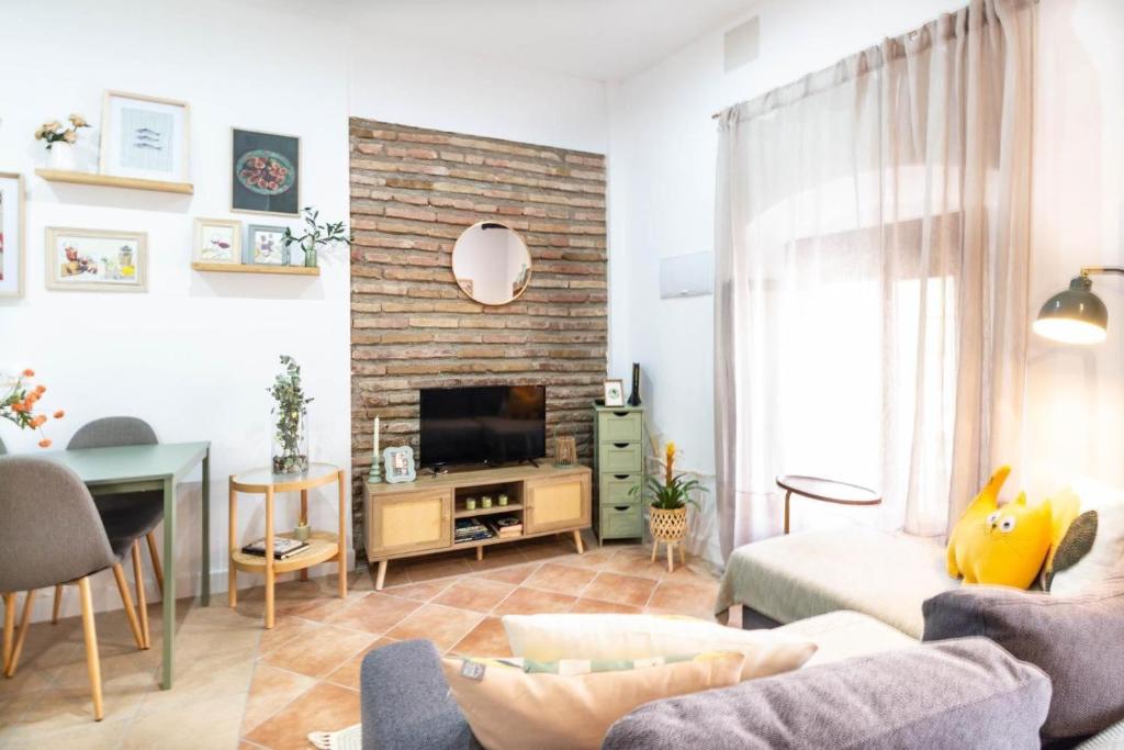 a living room with a couch and a tv at Casa Rubia Limón in Béznar
