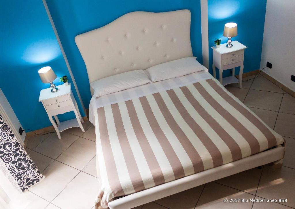 Blu Mediterraneo B&B في مسينة: غرفة نوم صغيرة بها سرير ومداخلة ليلتين