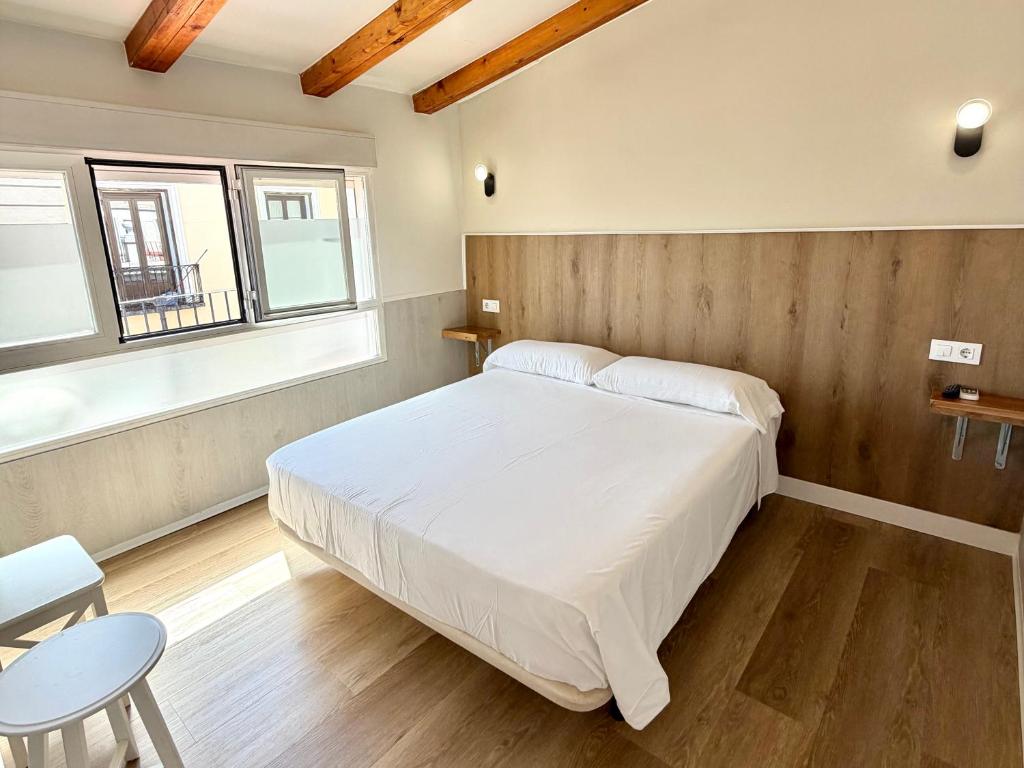 a bedroom with a white bed and a table and chairs at Apartamentos Mayor Centro in Madrid
