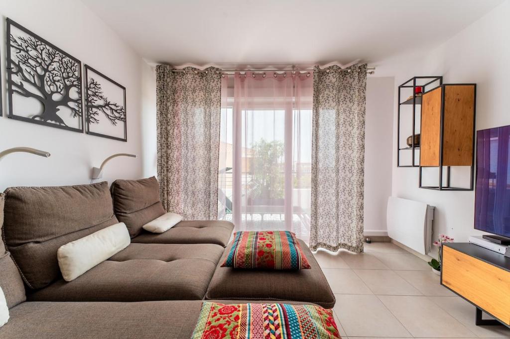 a living room with a couch and a tv at Le Cocon Dracénois in Draguignan
